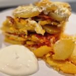 einfacher ungarischer Kartoffelauflauf auf Teller mit saurer Sahne