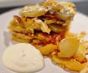 einfacher ungarischer Kartoffelauflauf auf Teller mit saurer Sahne