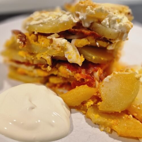 einfacher ungarischer Kartoffelauflauf auf Teller mit saurer Sahne