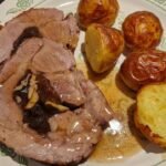 Einfacher Rullesteg (dänischer Schweinenacken-Rollbraten mit Backpflaumenfüllung) Rullesteg auf Teller mit Sosse und Kartoffeln