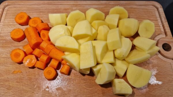 Kartoffeln und Karotten für den Eintopf vorbereiten