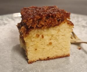 Stück dänischer Traumkuchen mit goldgelbem Biskuitboden und gebräuntem Kokosbelag