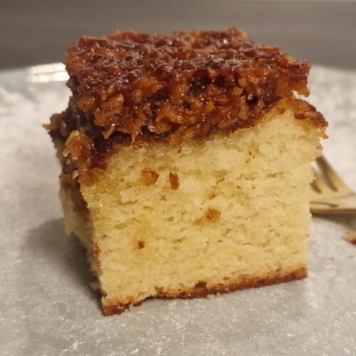 Stück dänischer Traumkuchen mit goldgelbem Biskuitboden und gebräuntem Kokosbelag