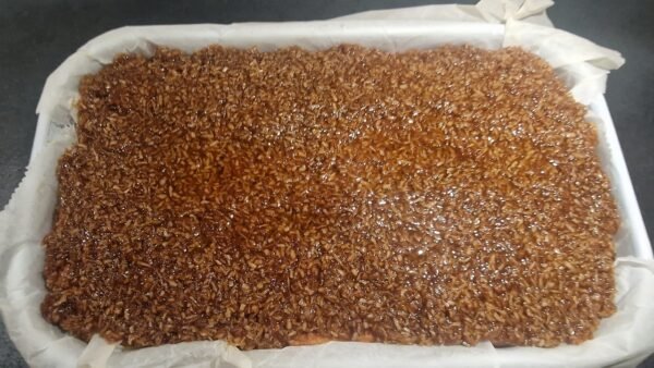 Kokosbelag auf dem Kuchenboden verteilt