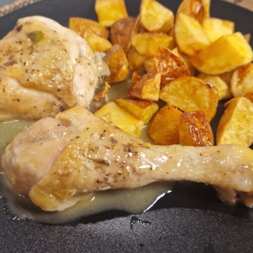 Pollo al ajillo mit Bratkartoffeln auf einem Teller