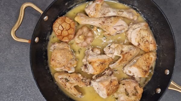 Gegartes Knoblauchhähnchen in seiner Sauce in einer Pfanne