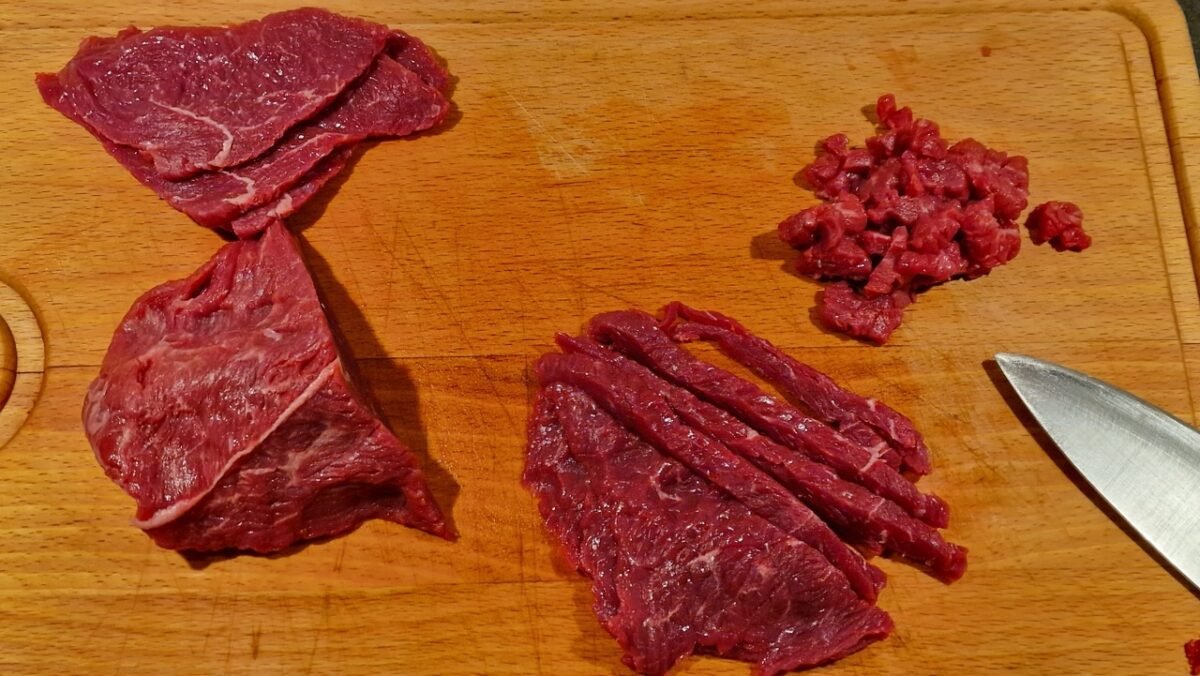 Rindfleisch wird für Steak Tartare in kleine Würfel geschnitten